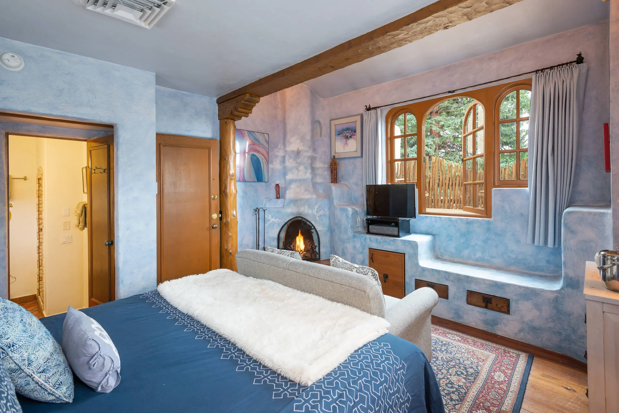 Sky Room with king bed, kiva fireplace, and romantic window that steps out on private deck