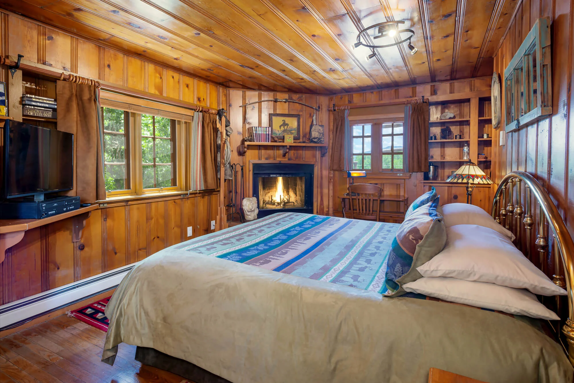 King bed in Happy Trails Room has several windows looking over the grounds