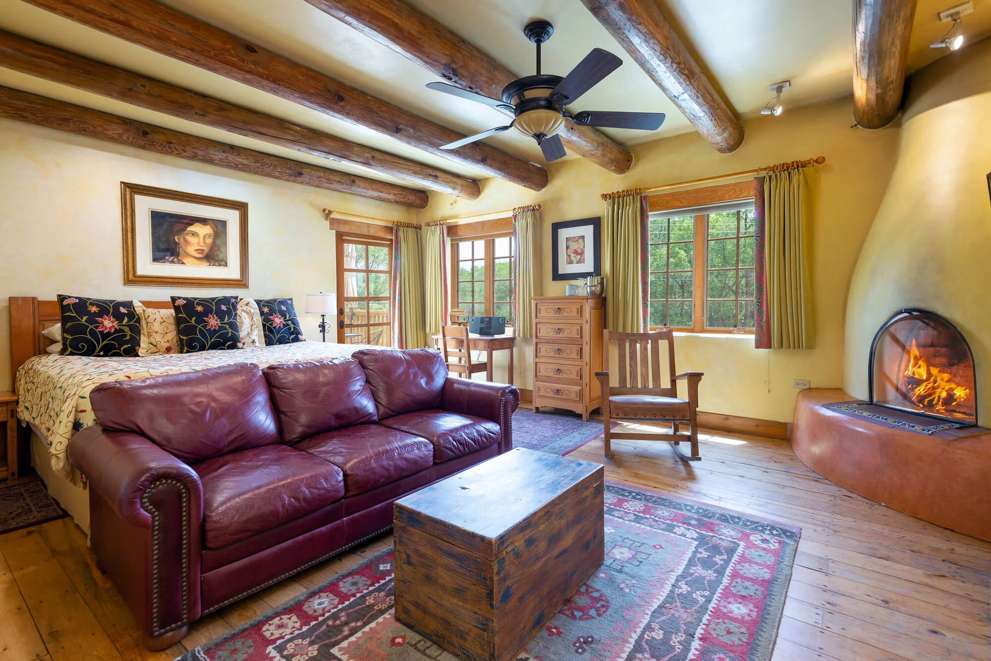 Spanish Colonial king room with queen sleeper sofa, kiva fireplace, and private deck