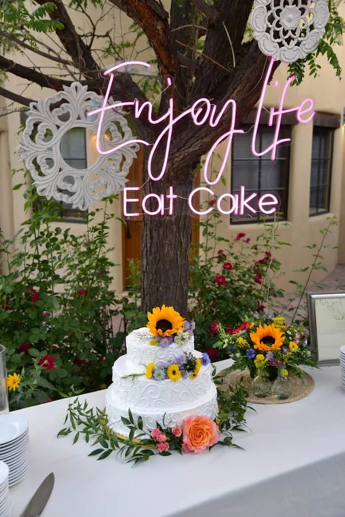 wedding cake with a sign that reads Enjoy Life, Eat Cake